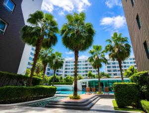 a view of a building with palm trees at Spacious Studio Near BTS Kitchen & Washer in Amphoe Phra Khanong
