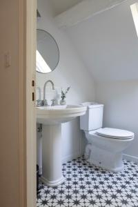 a white bathroom with a sink and a toilet at Moulin Dorceau - 15 couchages - voir notre site in Rémalard +44 photos
