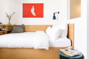 a bedroom with a white bed and a red painting at STAYERY Berlin Friedrichshain - stylish Rooms & Apartments in Berlin