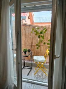 a sliding glass door with a chair and a table at N&K Yellow Pearl Flat in Volos