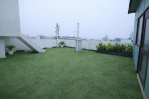 a balcony with green grass on a building at Hotel Almora Suites - Near Delhi Airport in New Delhi