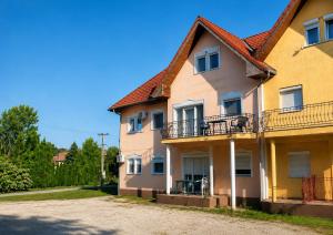a yellow house with a red roof at Katica Apartman in Kehidakustány