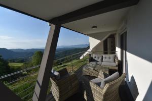 a balcony with wicker chairs and a view of the mountains at Slovenia Valley Views in Lipa pri Frankolovem