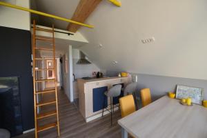a kitchen and dining room with a table and a kitchen and a ladder at Slovenia Valley Views in Lipa pri Frankolovem