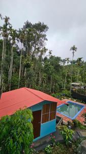 a house with a red roof and a swimming pool at WildCliff pool huts in Meppādi