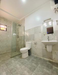 a bathroom with a toilet and a sink and a shower at SUITE De PARIS in Abuja +7 photos