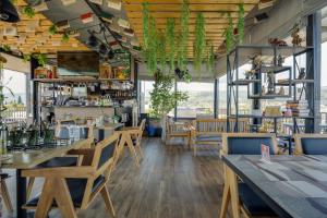 a restaurant with wooden tables and chairs and windows at Hotel Livin in Tbilisi City