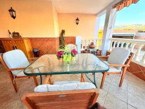 a glass table with a vase of flowers on it at Villa Mansa in Pechina