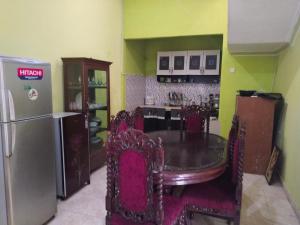 a kitchen with a dining room table and a refrigerator at Priv garut in Garut