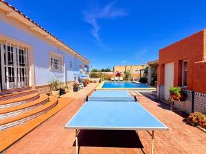 a patio with two tennis tables in front of a house at Villa Mansa in Pechina