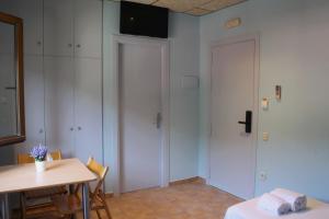 a room with a table and a white door at Hotel Al Riu in Bagá