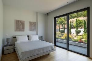 a bedroom with a bed and a large window at Aurora Residence by A&D Properties in Neos Voutzas +38 photos
