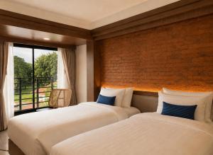 two beds in a room with a window at Wangkaew Hotel, Phitsanulok in Phitsanulok +74 photos