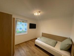 a bedroom with a bed and a window at Ferienhaus Meisterl in Sankt Marein bei Neumarkt