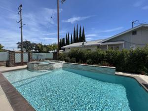 a swimming pool in the backyard of a house at Beautiful Remodel 3 Bedroom 2 bathroom Home with Pool & Jacuzzi in Fullerton