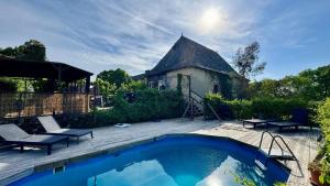 a yard with a swimming pool and a building at Gîte authentique avec piscine en Aveyron in Morlhon-le-Haut