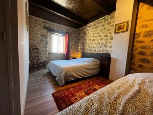 a bedroom with two beds and a window at Gîte authentique avec piscine en Aveyron in Morlhon-le-Haut
