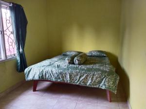 a bed with two cats sleeping on it in a room at Priv garut in Garut