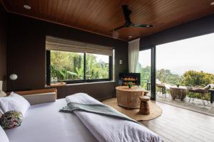a bedroom with a bed and a large window at Wanagiri Reserve in Gitgit