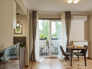 a living room with a table and chairs and a balcony at Sunrise Apartments City Center in Bucharest