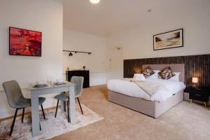 a bedroom with a bed and a table and a desk at Stockton Suites in Stockton-on-Tees