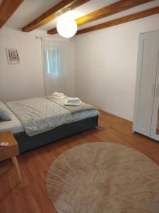 a small bedroom with a bed and a rug at Loparina House in Nerezine