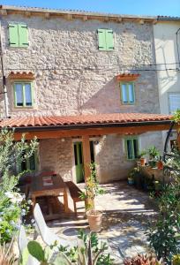 a stone house with a table in front of it at Loparina House in Nerezine