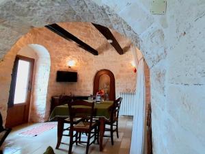 a dining room with a table in a stone wall at B&B La Rosa dei Trulli Alberobello in Alberobello