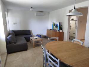 a living room with a table and a couch at Loparina House in Nerezine