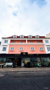 ein großes orangefarbenes Gebäude mit einer Ladenfront in der Unterkunft Hotel Nobu Peniche in Peniche