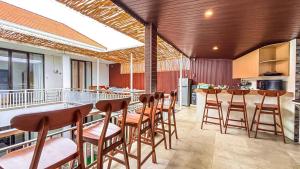 a kitchen with a bar with wooden stools at Agung Guest house Canggu in Dalung