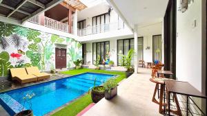 a villa with a swimming pool in a courtyard at Agung Guest house Canggu in Dalung