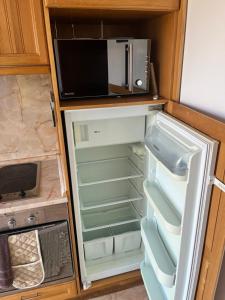 ein offener Kühlschrank mit einer Mikrowelle darauf in der Unterkunft Villa Dreams in Golf Club Ibar in Dolna Banya