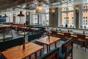 an empty restaurant with wooden tables and chairs at Whitworth Locke in Manchester +16 photos