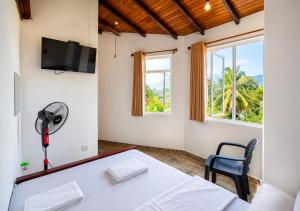 a room with a white table and a fan at Namali Guest House in Badulla