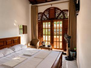a bedroom with a bed and a large window at Namali Guest House in Badulla