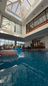 a large swimming pool in a building with a chandelier at شالية هواك in Al Ḩadd +12 photos