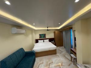 a bedroom with a bed and a blue couch at Hotel Skyline in Janakpur +33 photos