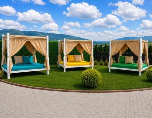 two beds in a yard with mountains in the background at Hotel & Resort Bon Bon in Skopje