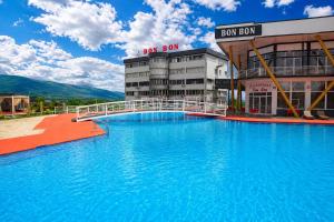 a large blue swimming pool in front of a building at Hotel & Resort Bon Bon in Skopje