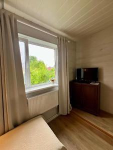 a room with a large window and a television at Liiva Guest Accommodation,free parking in Tartu