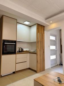 a kitchen with white cabinets and a counter top at Apartman Đurišić in Prijevor