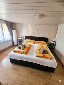a bedroom with a large bed with two pillows on it at Ferien im Paradies - Zwischen Bergen & Seen in Brienzwiler