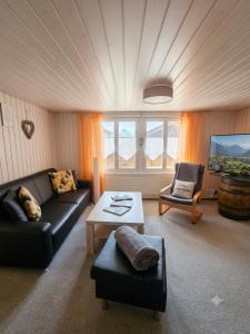 a living room with a couch and a table at Ferien im Paradies - Zwischen Bergen & Seen in Brienzwiler