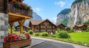 a building with flowers in front of a mountain at Ferien im Paradies - Zwischen Bergen & Seen in Brienzwiler