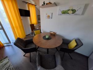 a dining room with a wooden table and chairs at Lemon Garden Villapark in Bükfürdő