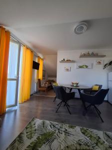 a living room with a table and chairs in it at Lemon Garden Villapark in Bükfürdő