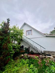 a white house with a staircase on it at Liiva Guest Accommodation,free parking in Tartu