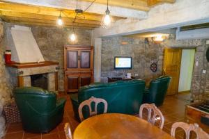 a restaurant with green chairs and tables and a fireplace at Casa das Marias by Gerês Casas in Geres