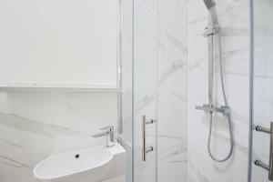 a white bathroom with a shower and a sink at APod in Coventry